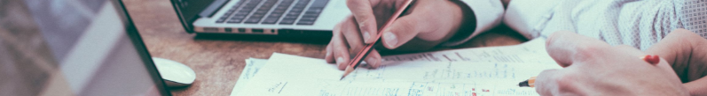A person writing on a sheet of paper.