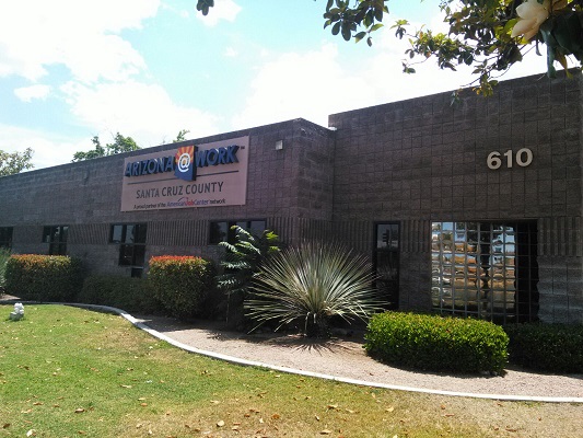 A dark gray building with a sign that reads: ARIZONA@WORK Santa Cruz County.