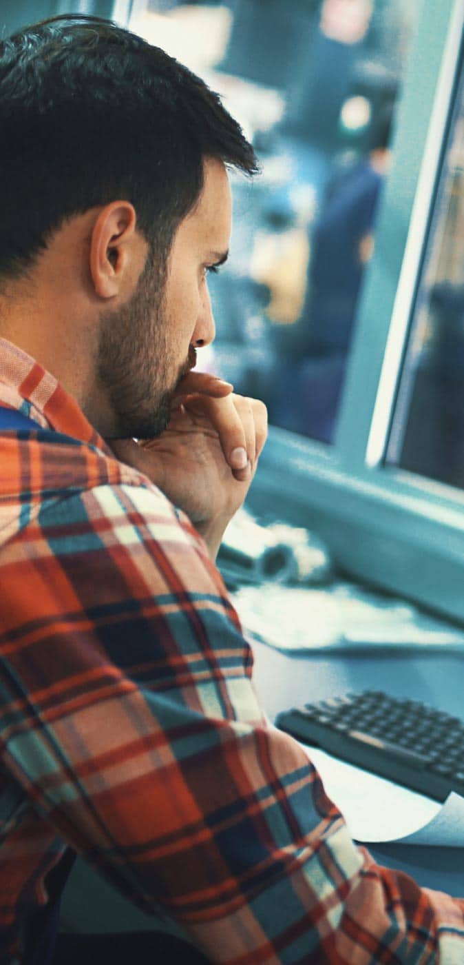 Guy sitting at the desk working on his computer
