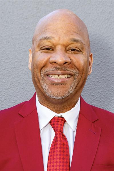 Professional headshot of a person in a red blazer.